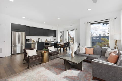 Spacious, comfortable living room with a Smart TV, open floor plan leading to the kitchen & dining area, and plenty of natural light.