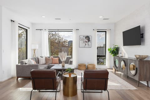 Spacious, comfortable living room with a Smart TV, open floor plan leading to the kitchen & dining area, and plenty of natural light.