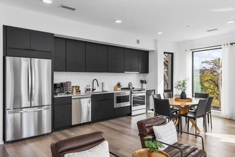 Spacious, comfortable living room with a Smart TV, open floor plan leading to the kitchen & dining area, and plenty of natural light.