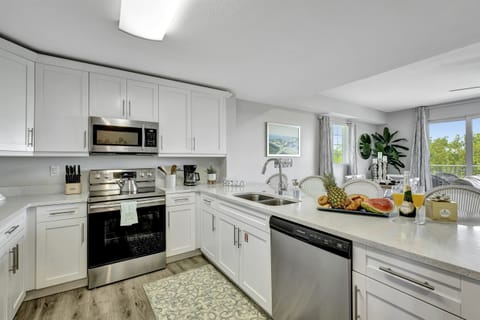 The kitchen, a space that transcends mere functionality, welcomes you with its pristine elegance and modern charm.