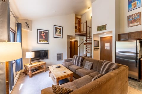 Living area offering cozy furnishings, a gas fireplace and vaulted ceilings.