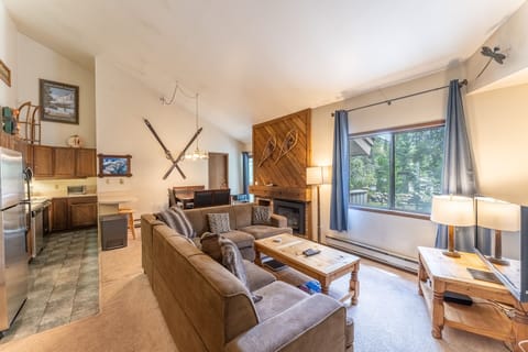 Living area offering cozy furnishings, a gas fireplace and vaulted ceilings.