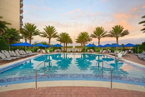 Soak up sunshine with loungers, palms, and peaceful water views.