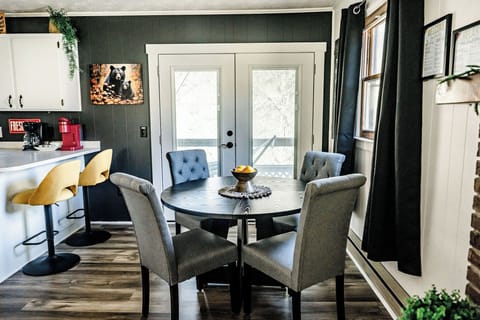 A cozy dining area with a table, comfy chairs, and a view of the outdoors.