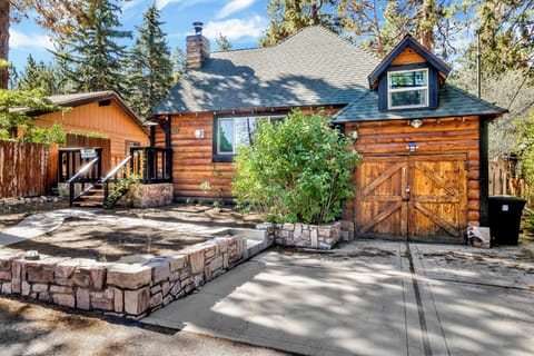 Welcoming cabin entry surrounded by towering pine trees, offering fresh mountain air and a peaceful forest setting—the perfect first impression for your Big Bear Lake getaway.