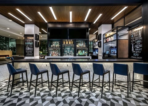 Sip craft cocktails beneath warm lighting at the sleek bar.