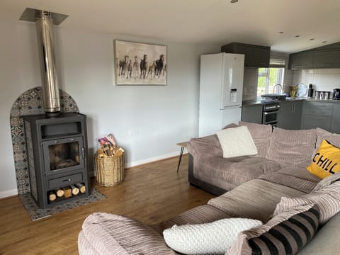 Spacious open plan lounge, dining and kitchen area with log burner. 