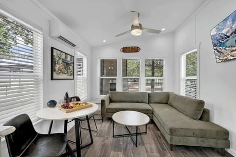 The snug living room seamlessly transitions into a quaint dining area, creating an intimate and charming space