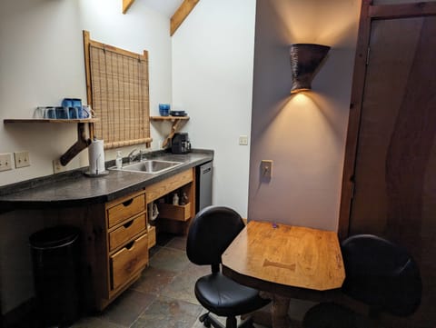 Kitchenette with a cooktop, toaster oven, microwave, fridge, coffee pot & dishes