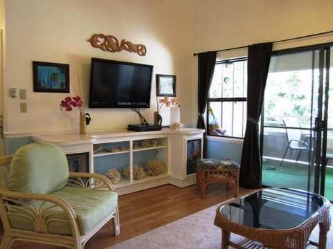 Sink into the sofa in your bright living area, where tropical touches and a flat-screen TV create a relaxing retreat. Step through the doors to your private balcony and enjoy the green views beyond.