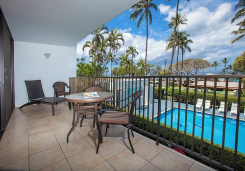 Relax on your private balcony overlooking the sparkling pool and swaying palms. Enjoy morning coffee at your outdoor table while soaking in ocean breezes and tropical views.