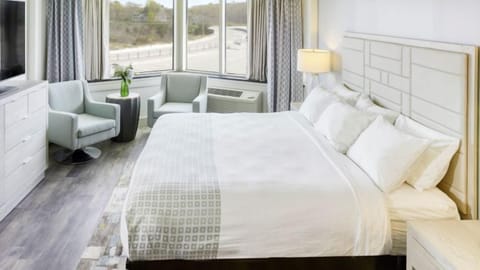 Unwind in a bright king room with cozy chairs.