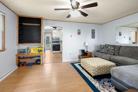 The living room features a sectional sofa, tv, ceiling fan, and air conditioner.