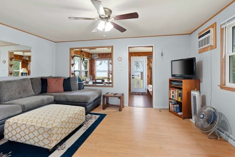 The living room features a sectional sofa, tv, ceiling fan, and air conditioner. 