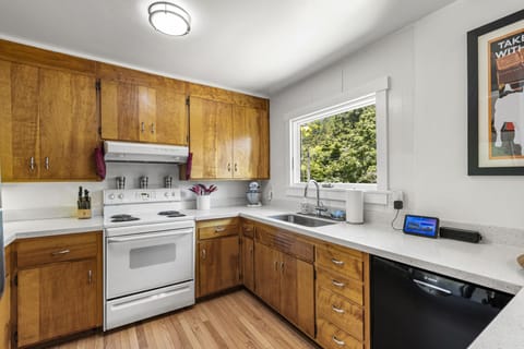 A full kitchen including dishwasher and electric stove.