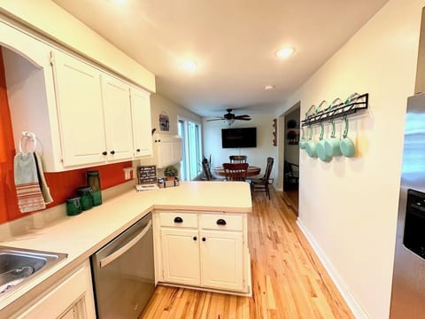Kitchen with eat-in bar, table for 4 and wall-
mounted TV.