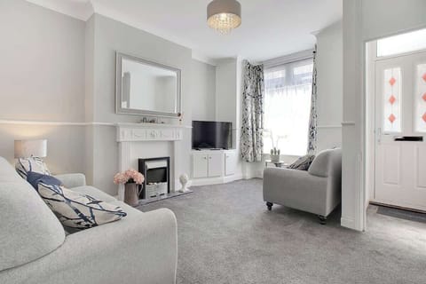Bright and comfortable living area with cosy seating and a Smart TV — perfect for relaxing after a day out.