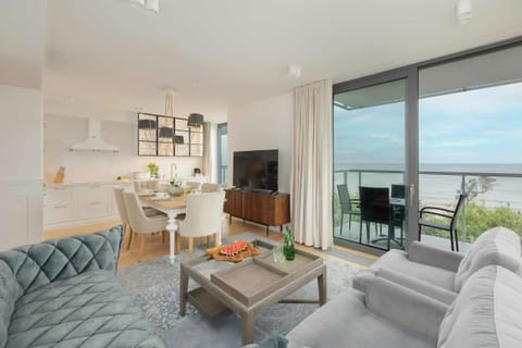 A wide view of the living and dining space, showcasing its open layout and ocean view.

