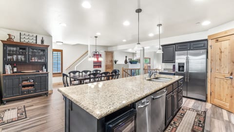 - Bright open kitchen with granite counters and stainless steel fridge  
- Large island with sink and extra seating for casual family meals  
- Easy access to dining area with open flow for group gatherings