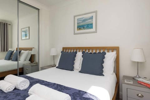 Bright and cosy double bedroom with soft linens, perfect for a relaxing coastal retreat.