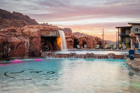 Red rock waterfall splashing into the pool
