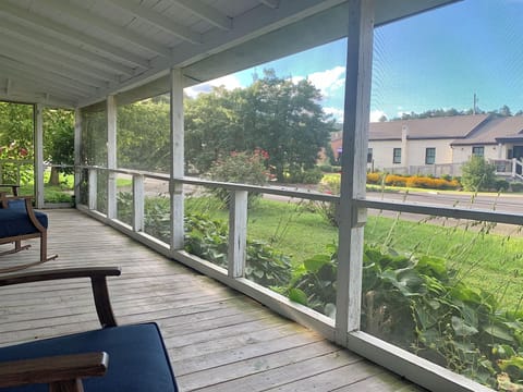 Screened front porch with comfortable rocking chairs, a high top table & chairs.