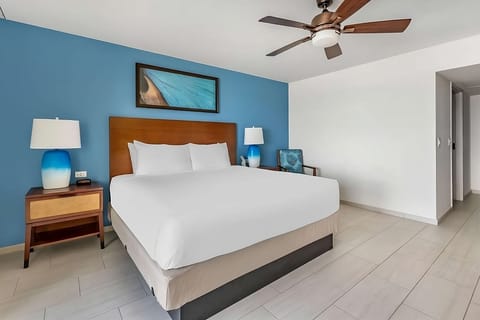Sink into a plush king bed beneath a quiet fan.