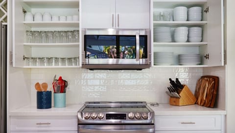 Fully stocked kitchen with sharp all kitchen instruments (sharp knifes, spatulas, cutting boards, measuring cups, and more)and elegant quality plate settings