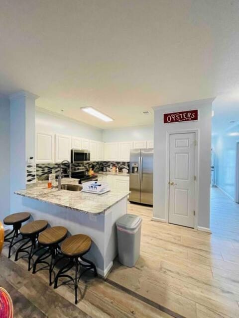 Kitchen with new appliances. Stainless steel glass top stove, microwave, fridge.