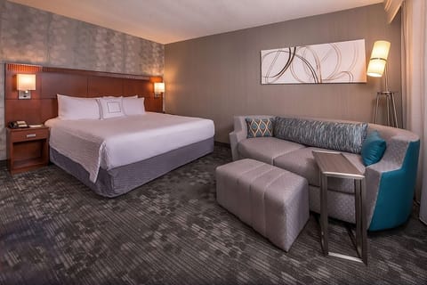 Unwind in a spacious king room with cozy lounge seating.