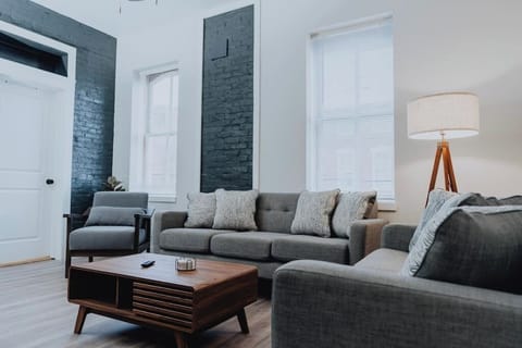Living room — sectional seating, smart TV, and tall windows in a historic Soulard building