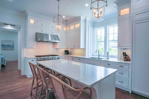 The kitchen features a center island, custom cabinetry, high end appliances and a tiled backsplash.