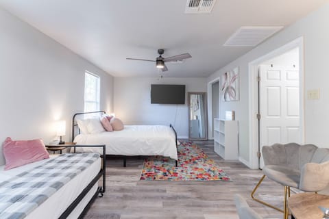 Nestle into comfort with plush bedding and a daybed in this inviting bedroom. Enjoy amenities like a mounted TV, full-length mirror, and elegant chair for a truly restful stay.