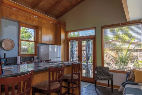 Back house kitchen and granite counter island with barstools