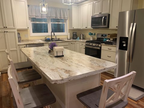 Kitchen island seating up to six persons. Extra barstools in the living room.