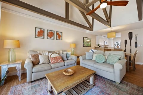 Bright living room with vaulted ceilings and cozy seating. A warm, inviting space to relax.