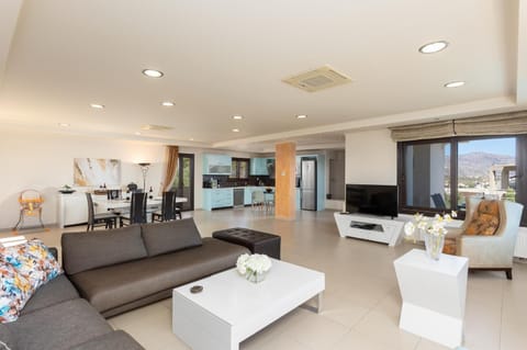 Open-plan living room with sofas, dining area, kitchen, A/C, WiFi internet, satellite TV, and panoramic sea views