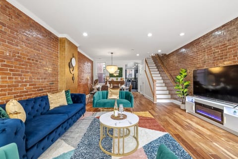 Enjoy a stylish open-concept living room with exposed brick, plush seating.