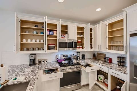 Enjoy the full kitchen and dining area with a refrigerator, freezer, oven, stove, microwave, dishwasher, coffee, creamers, mixers, spices, pots, pans, cooking supplies, cutlery, cups, plates, bowls, utensils, small appliances, and many more essentials.