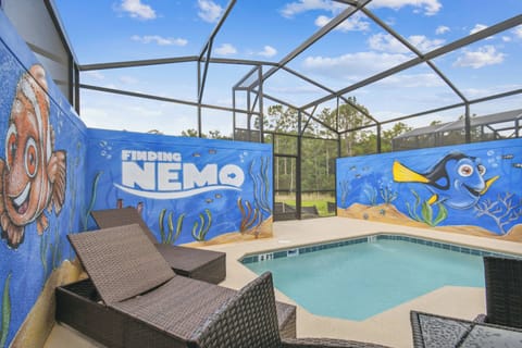 Dive into fun with this vibrant pool area, featuring whimsical murals of beloved characters against a backdrop of clear skies. Relax on stylish lounge chairs, surrounded by a screened enclosure that invites sun-soaked afternoons.