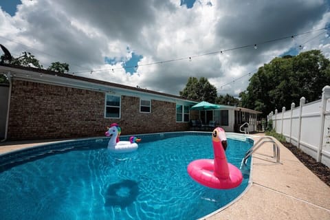 Large pool with lounge chairs, outdoor dining, and inflatables