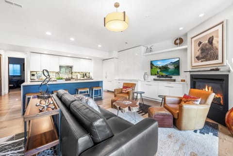 - Enjoy an open concept living room with fireplace warmth  
- Leather chairs and sofa create a stylish gathering spot  
- Modern kitchen island with seating completes the space