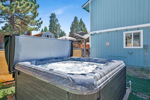 Spacious backyard with a relaxing hot tub, BBQ, outdoor dining area, comfy seating, perfect for peaceful evenings outdoors.
