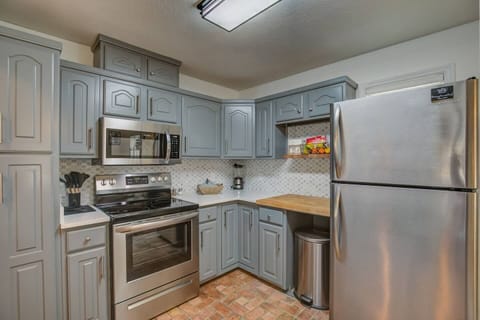 Full size refrigerator, stove and well stocked kitchen.