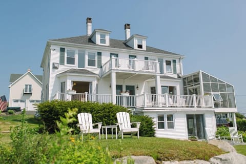 The Admiral's Quarters Inn is a classic New England retreat featuring wraparound decks, sunlit balconies, and charming white clapboard architecture—just steps from Boothbay Harbor's waterfront, shops, and coastal adventures.