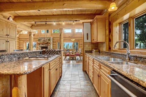 Fully functional kitchen with forest view opens up to the dining and living space