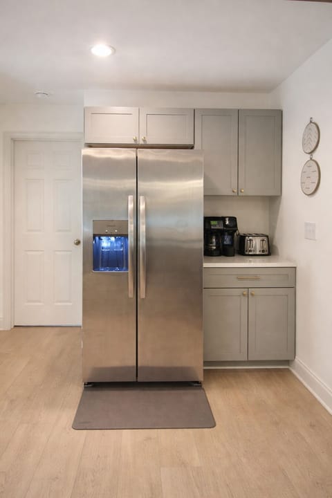 Dedicated coffee station with fridge, coffee maker, and essentials.