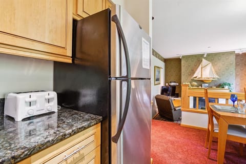 Fully equipped kitchen with stainless-steel appliances, granite countertops, and all essentials for meal prep — conveniently open to the dining and living areas.