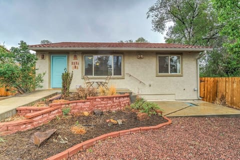 Welcoming single-story home with a wide driveway and a front yard finished in red gravel and curved brick planters. A mature tree and fenced side yard add greenery and privacy as you arrive and walk up the path to the front door.