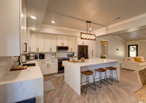 Modern kitchen with quartz island, wood bar stools, stainless appliances